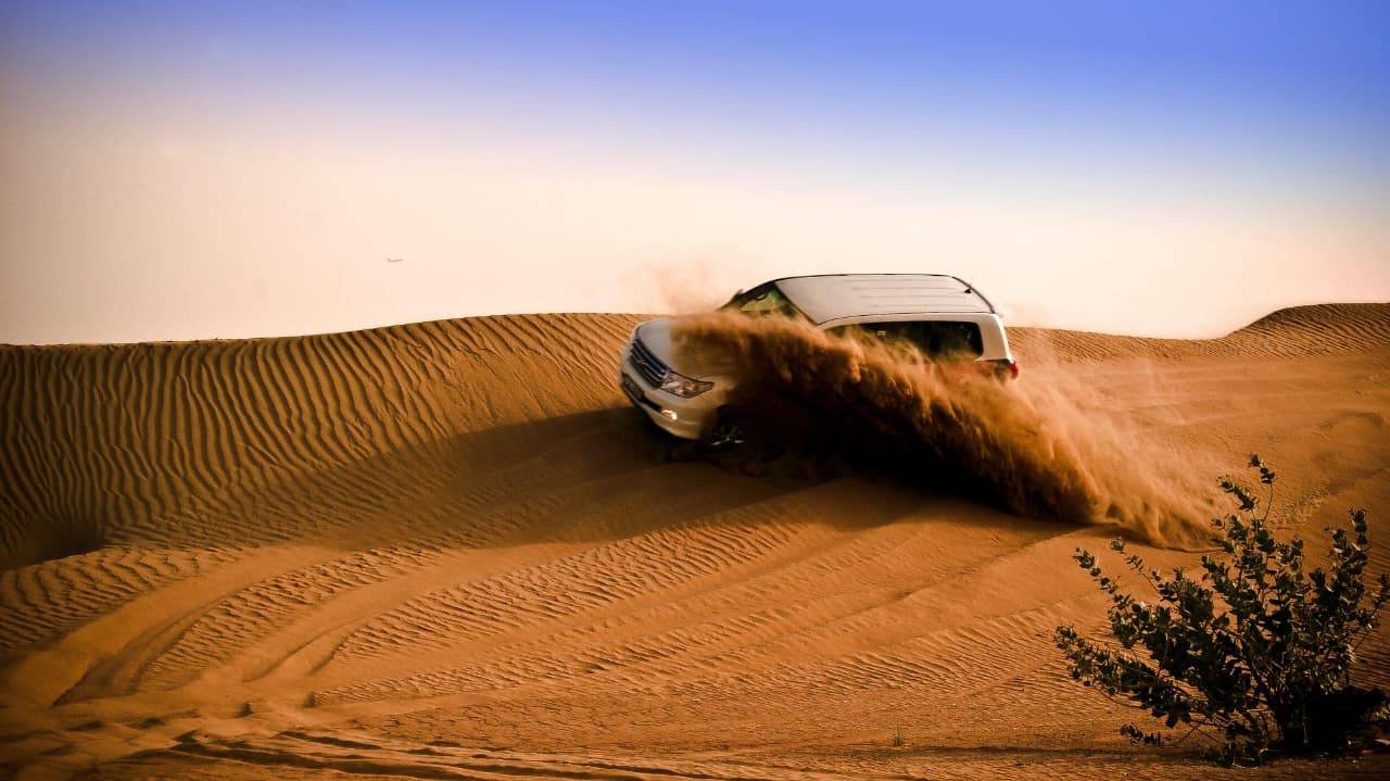4x4 vehicle dune bashing on the red sand dunes of the Dubai desert